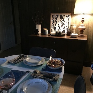 Small table set in a warmly lit room, with a lamp glowing behind it